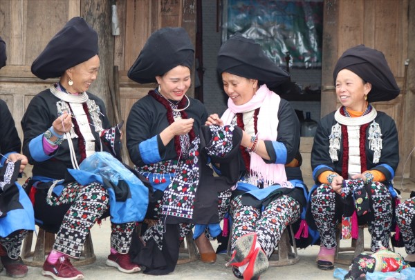 Những người phụ nữ Dao cùng nhau thêu thùa chuẩn bị quần áo mới cho ngày tết. Ảnh: Thùy Anh